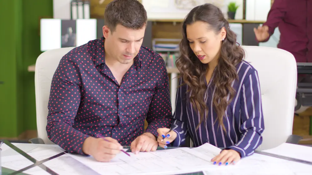 two people discussing blue prints